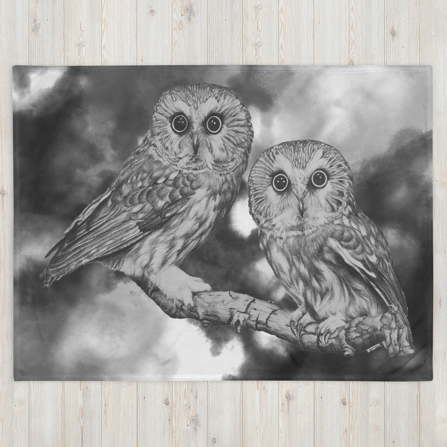 The "Owl Throw Blanket" is of two owls sitting on a branch with a "Who's That" look, drawn with a graphite pencil with a gray and white cloud effect added to give it a dynamic look.