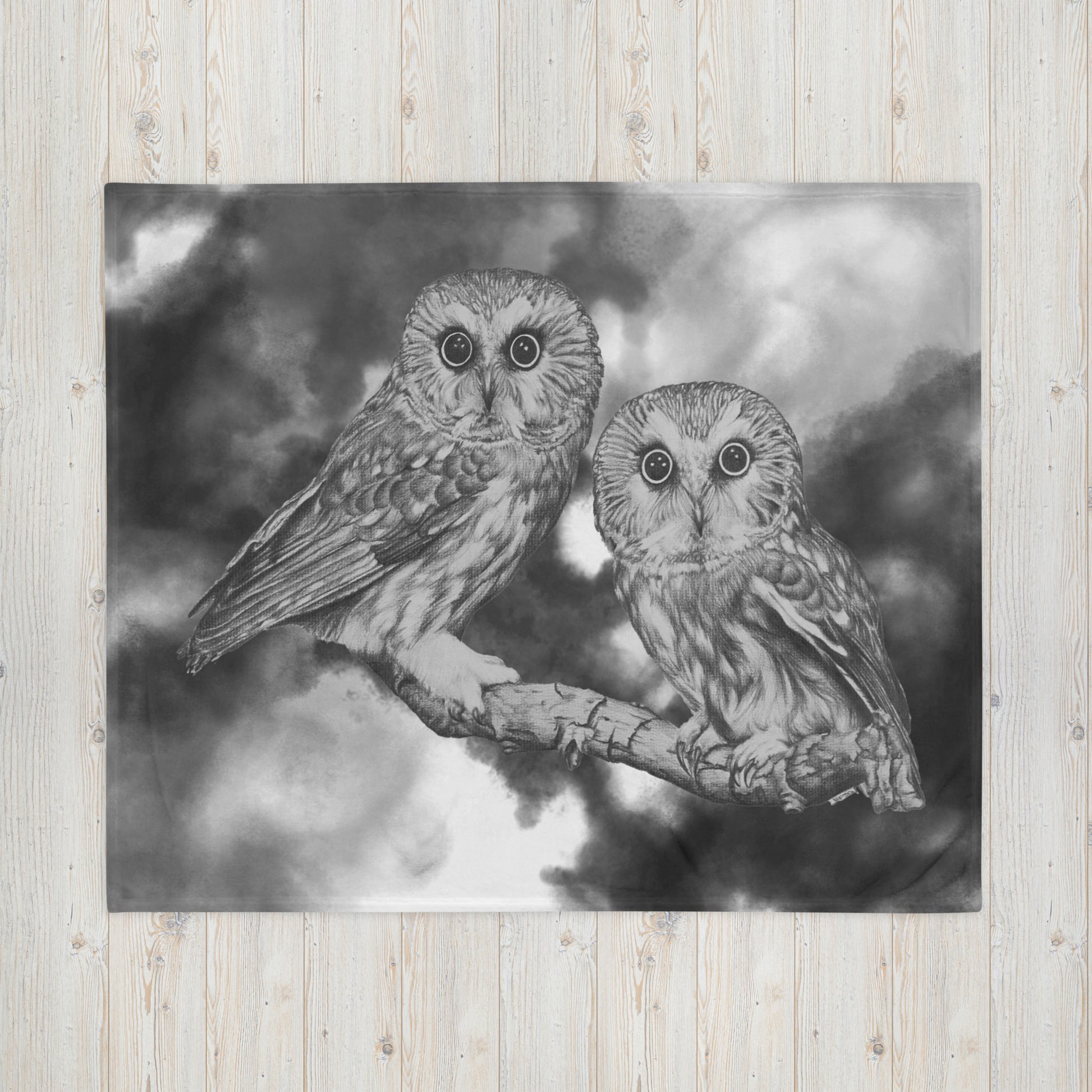 The "Owl Throw Blanket" is of two owls sitting on a branch with a "Who's That" look, drawn with a graphite pencil with a gray and white cloud effect added to give it a dynamic look.
